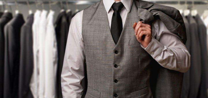 Mode und Bekleidung - Mann mit Anzug vor Kleiderständer